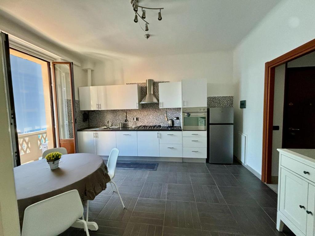 a kitchen with white cabinets and a table and chairs at Milano Flat - Primaticcio in Milan