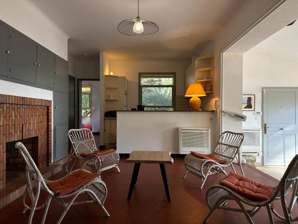 ein Wohnzimmer mit Stühlen, einem Tisch und einem Kamin in der Unterkunft Grande villa face à la plage, superbe vue mer in La Seyne-sur-Mer