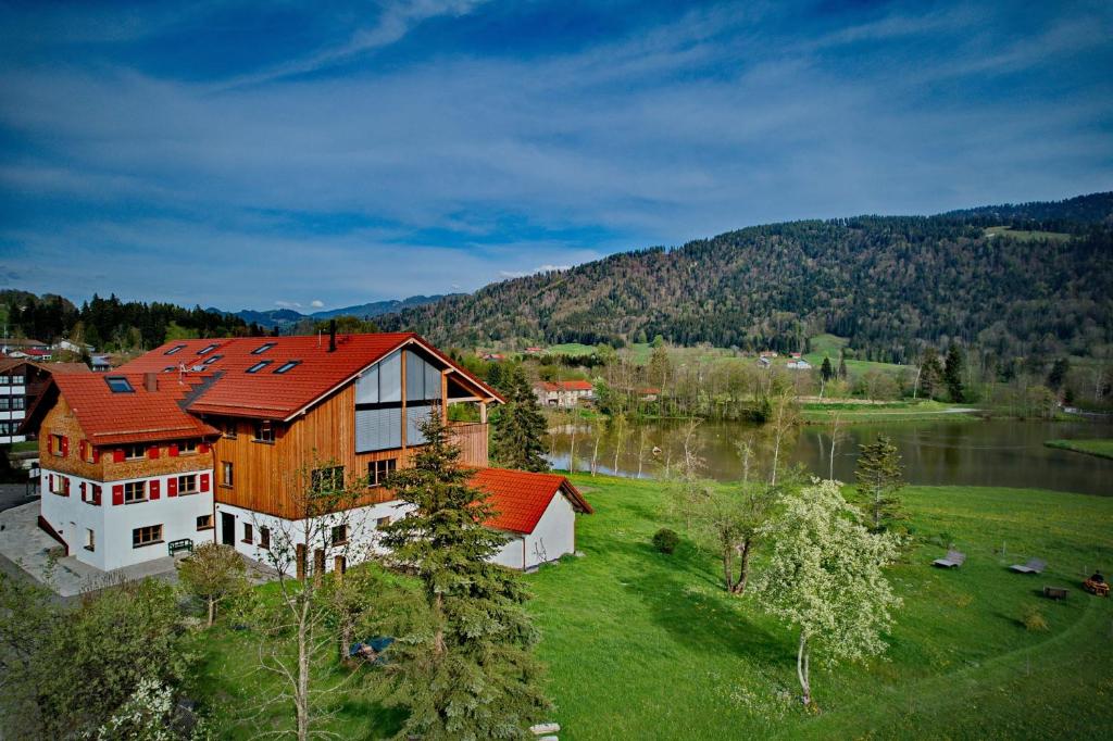 an aerial view of a house with a lake at Eibele Chalets in Oberstaufen