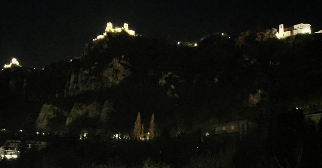 Una montaña de noche con luces en la parte superior. en B&B Da Noi en San Marino