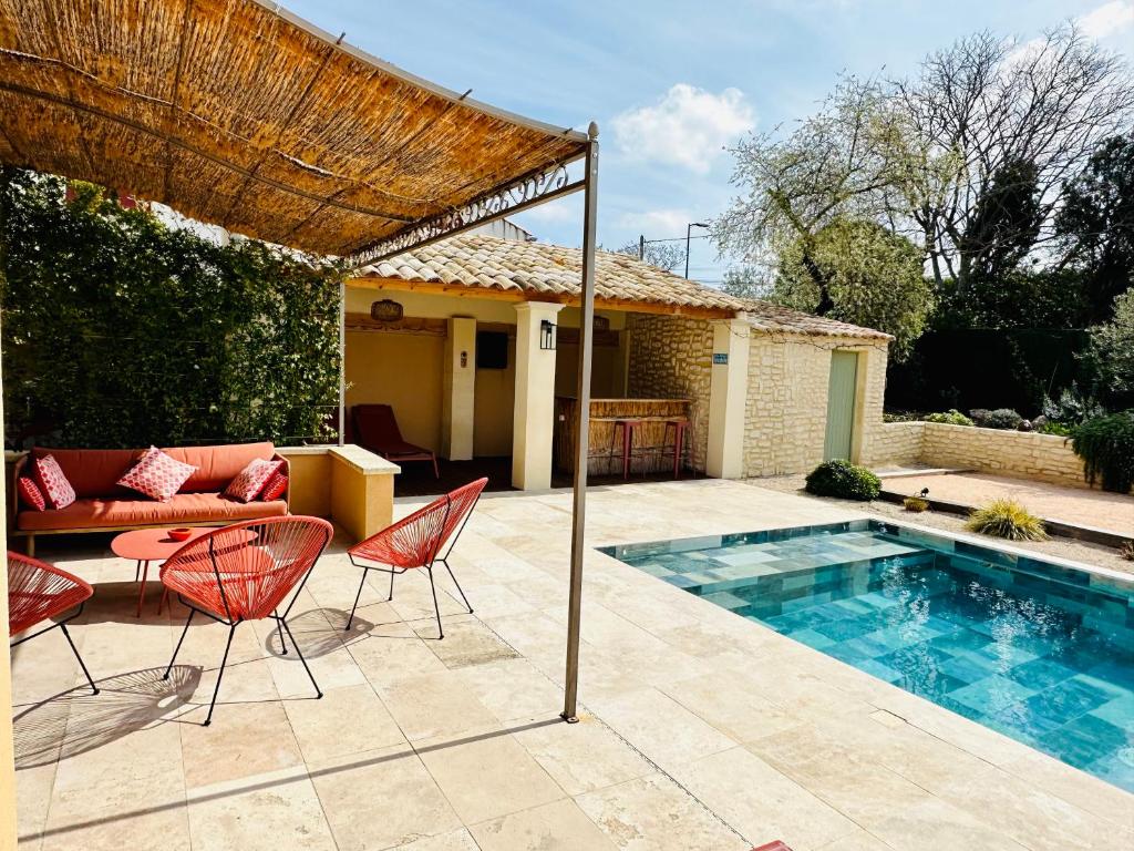 a patio with a couch and chairs and a pool at Le petit Mazet du Domaine avec sa piscine in Saint-Rémy-de-Provence