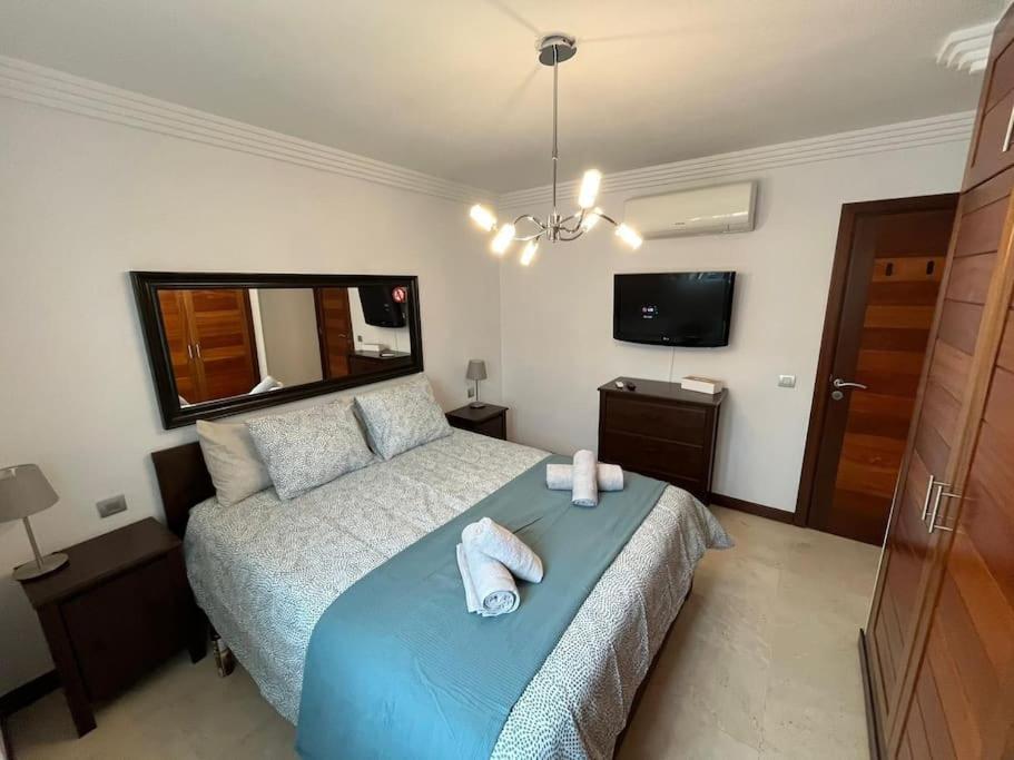 Un dormitorio con una cama azul con toallas. en Apartamento San Eloy con plaza de garaje en Playa Honda