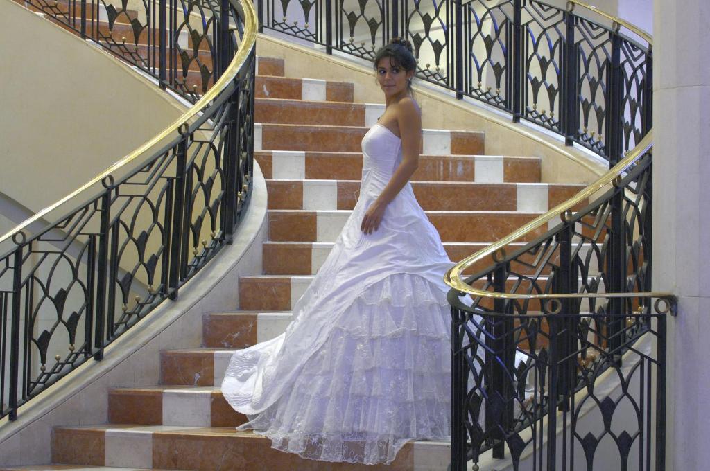 a woman in a white dress walking down stairs at Intercontinental Cairo Citystars by IHG in Cairo