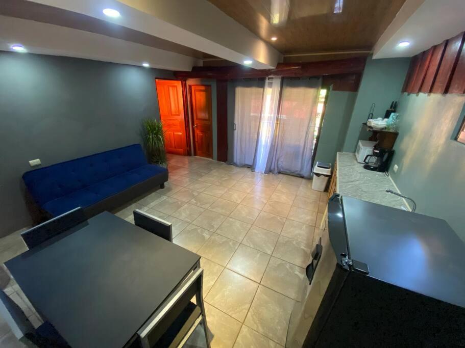 sala de estar con sofá azul y mesa en Tabaco Lodge #2 a solo 5 minutos de Playa Carrillo, en Carrillo