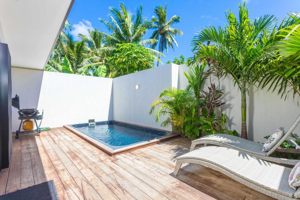 un patio con piscina en una terraza de madera en Atupa Suites en Avatiu