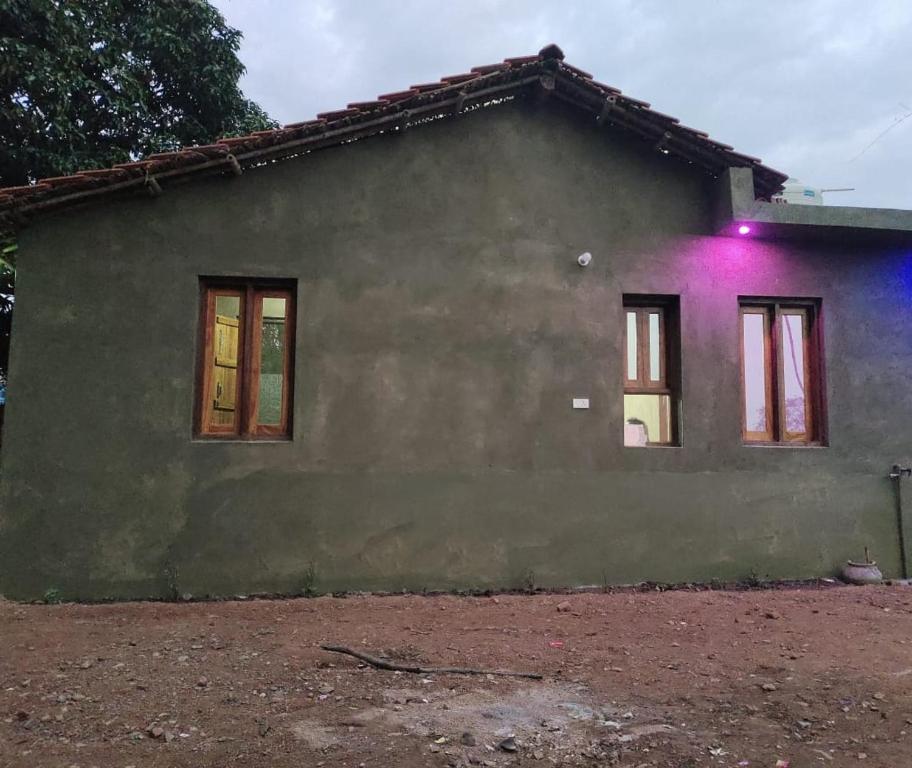 a house with a purple light on the side of it at Jungle joy Homestay Basata in Chhatarpur