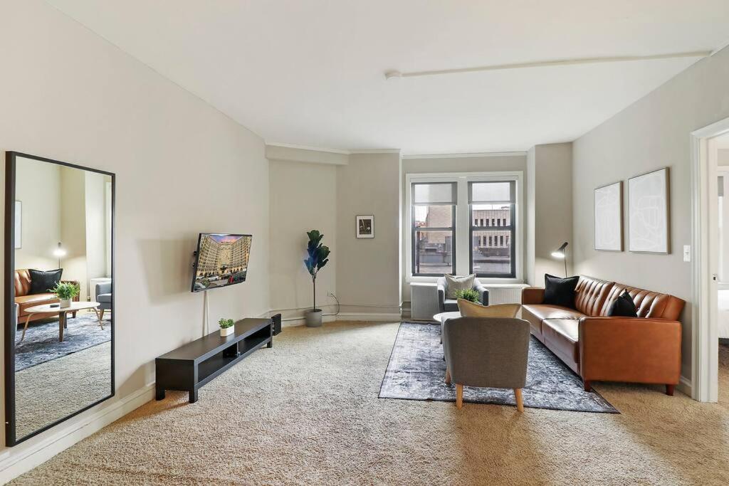 a living room with a couch and a mirror at 2BR Sunny Apartment in Hyde Park - Windermere 211 in Chicago