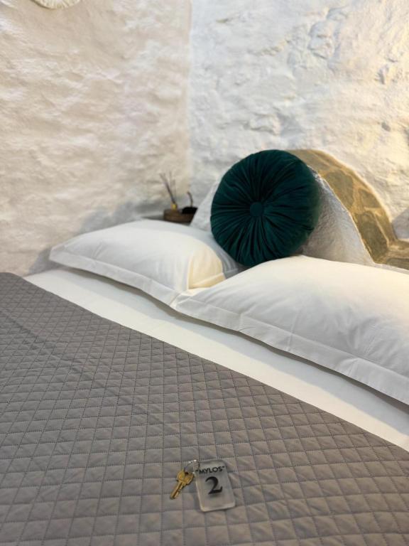 a bed with a green pillow on top of it at O Mylos in Ermoupoli