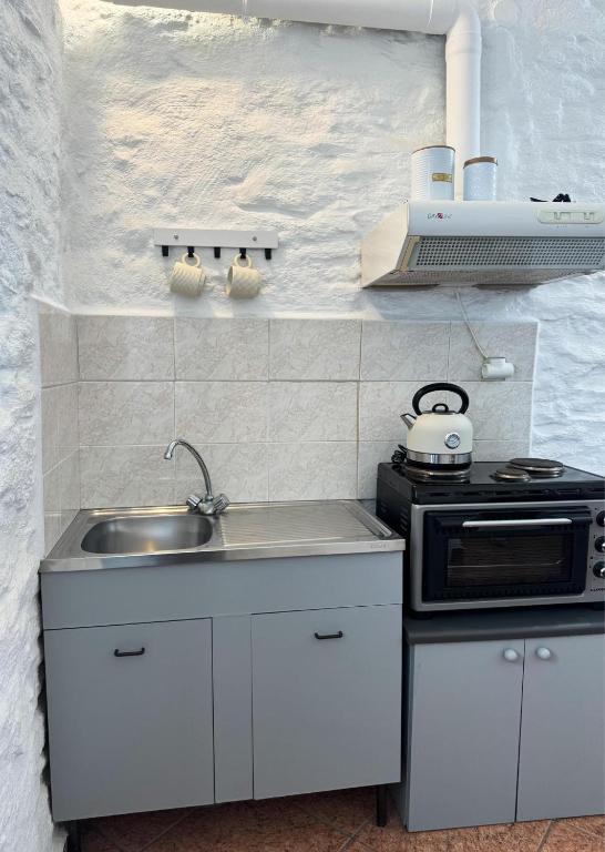 a small kitchen with a sink and a stove at O Mylos in Ermoupoli