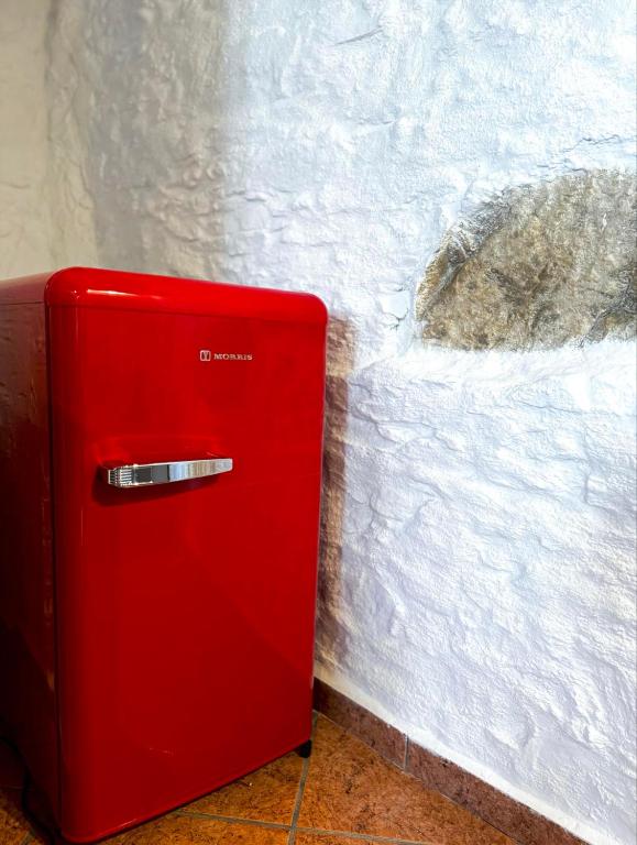 a red refrigerator sitting next to a white wall at O Mylos in Ermoupoli