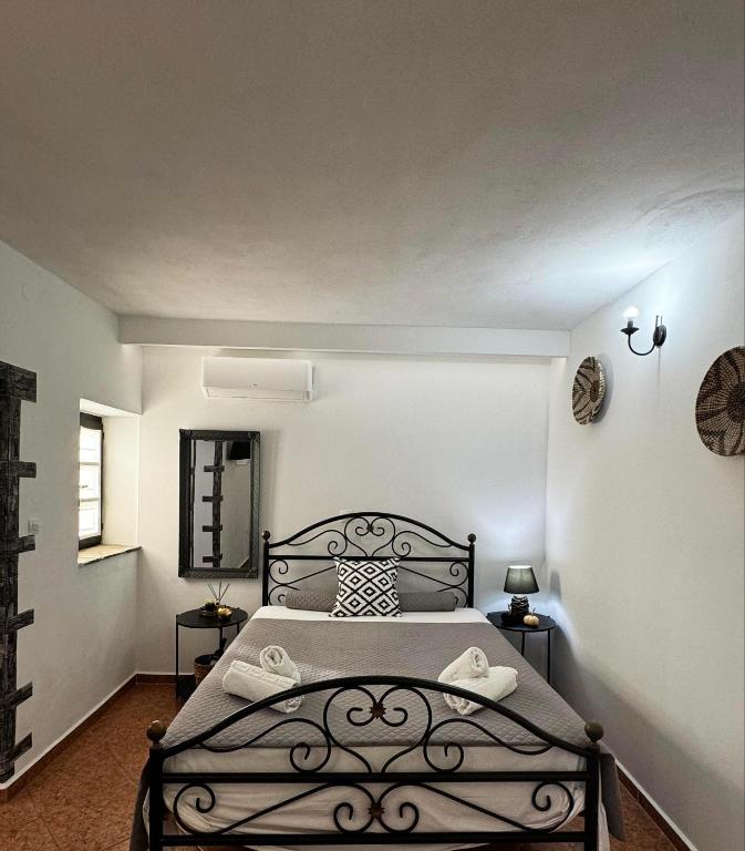 a bedroom with a black bed in a room at O Mylos in Ermoupoli