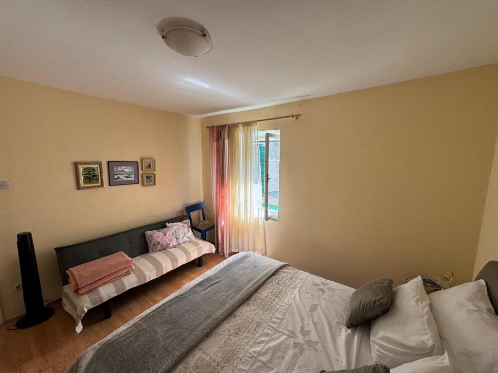 een slaapkamer met een bed, een bank en een raam bij Apartment Marijeta Kaštela in Kaštela