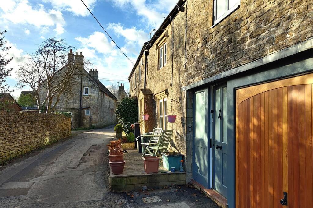 a brick building with a blue door and some plants at The Old Fire Station at Colerne in Chippenham