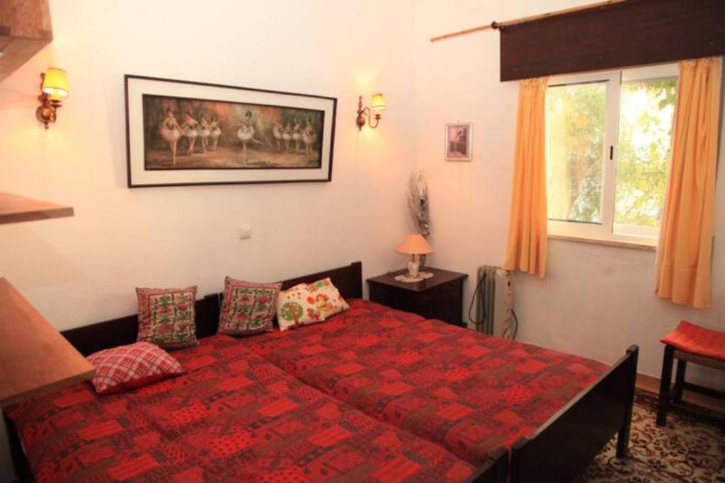 a bedroom with a bed with a red comforter at Casa Formiga RC2 in Porches