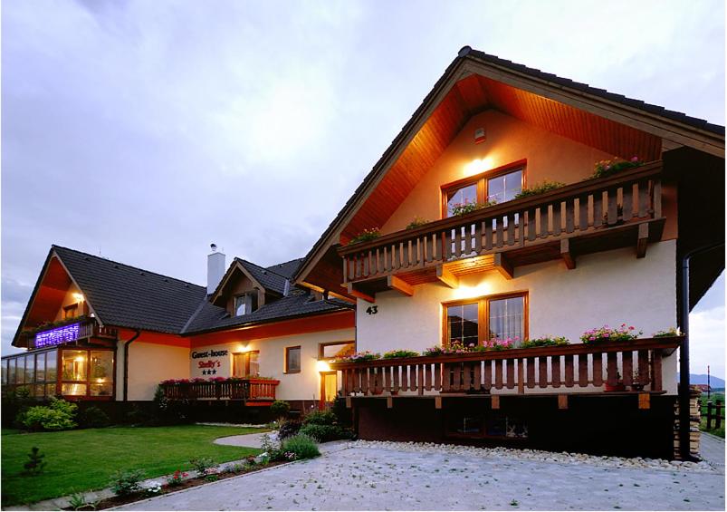 een groot huis met een balkon aan de zijkant bij Penzion u Šeliho in Veľká Lomnica