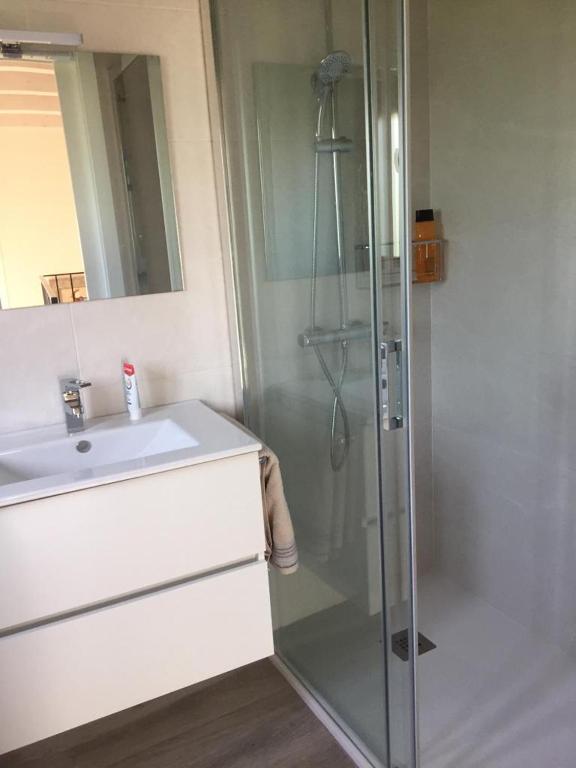 a bathroom with a glass shower and a sink at La casita de la abuela in Moaña