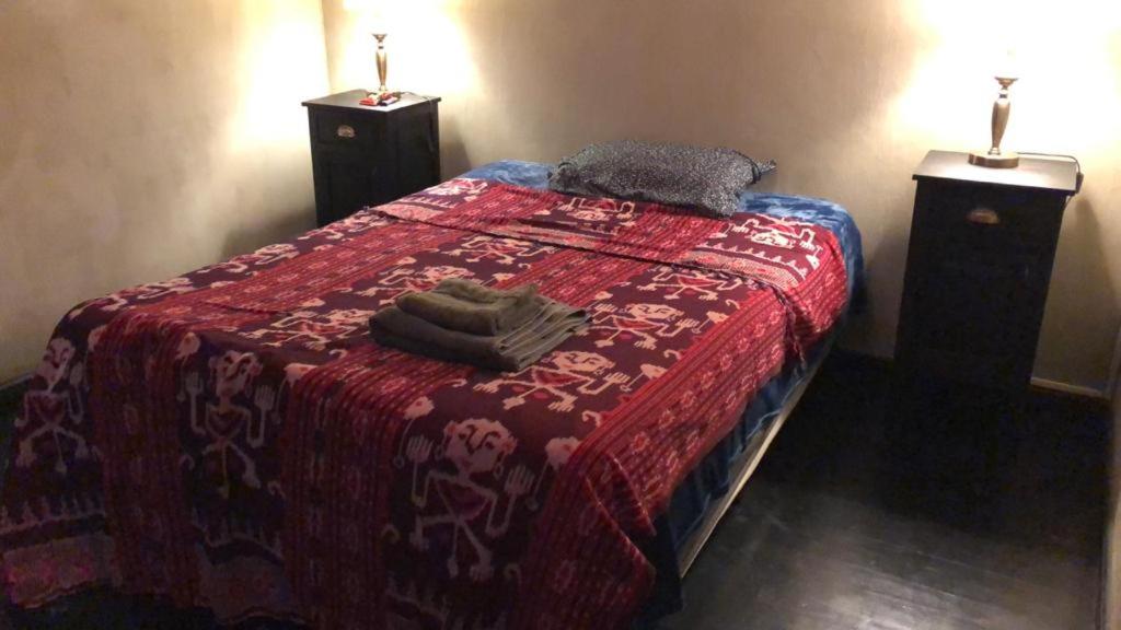 a bed with a red blanket and two towels on it at Balcarce in Buenos Aires