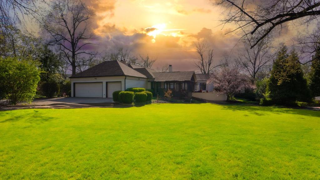 a house with a large yard with a green lawn at A Spacious Sanctuary for Unforgettable Group Stays in Olivette