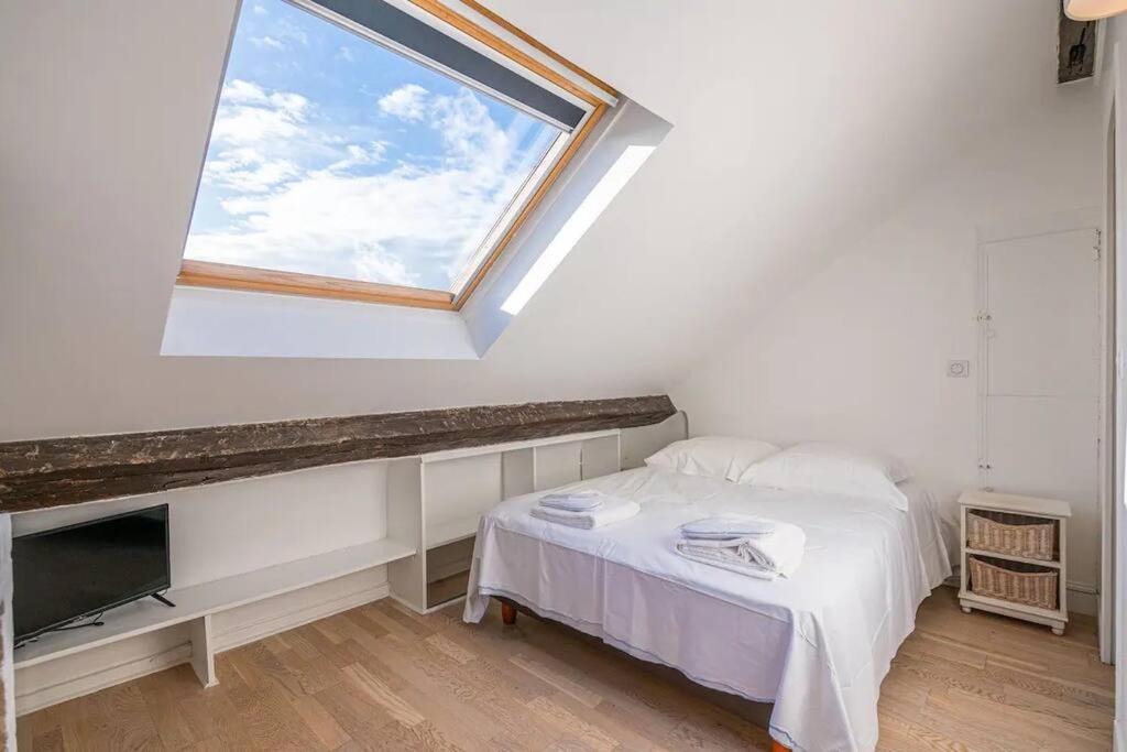 sypialnia z oknem dachowym, łóżkiem i oknem w obiekcie Amazing location only 3 minutes from Luxembourg Gargens w Paryżu