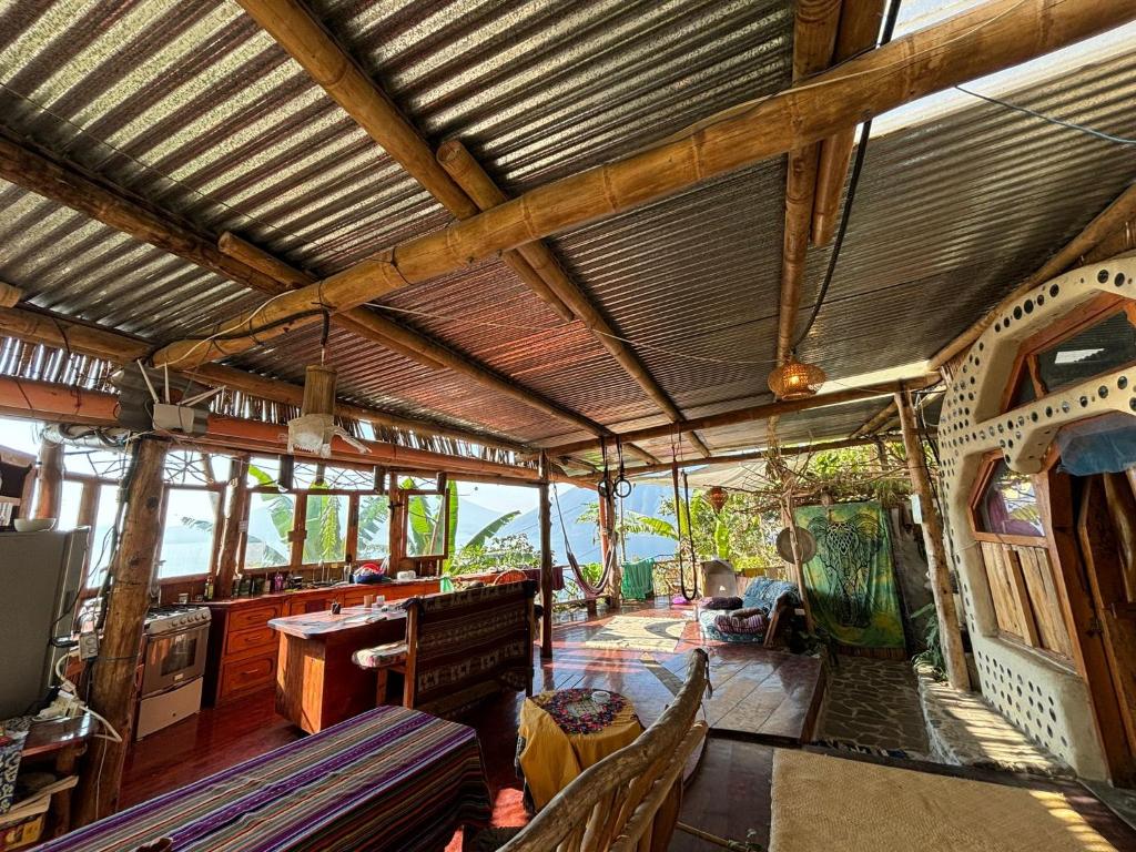 Cette grande chambre dispose d'un plafond en bois avec une table et des chaises. dans l'établissement Earthship 3 levels apartment starboard cabin with lake view, à San Marcos La Laguna