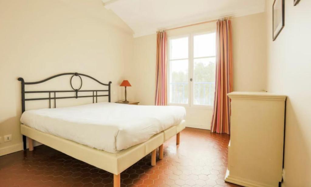 een slaapkamer met een groot bed en een raam bij One Palm in Grimaud