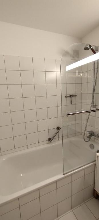 ein Badezimmer mit einer Dusche und einer weißen Badewanne in der Unterkunft SHARED Cozy place in Stuttgart's heart! in Stuttgart