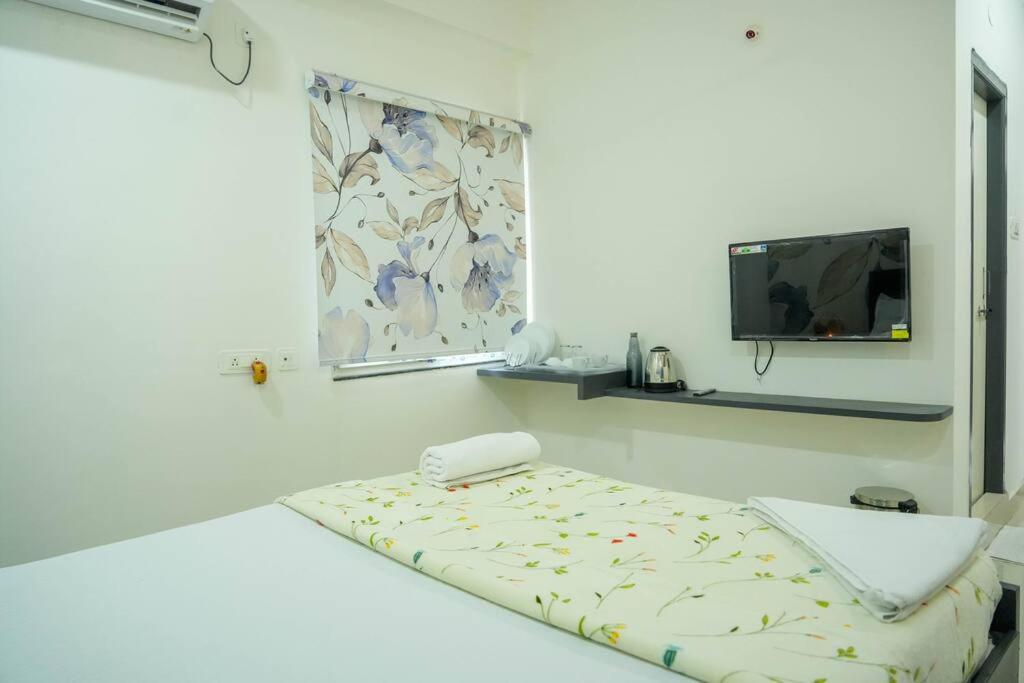 a white room with a bed and a tv at A/C room with Queen Bed Gachibowli in Hyderabad