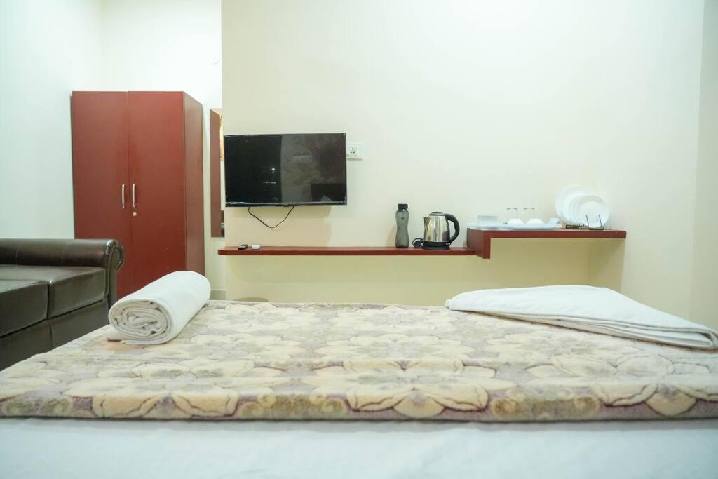 uma cama num quarto com uma televisão na parede em AC Queen Room Near Wipro Circle Gachibowli em Hyderabad