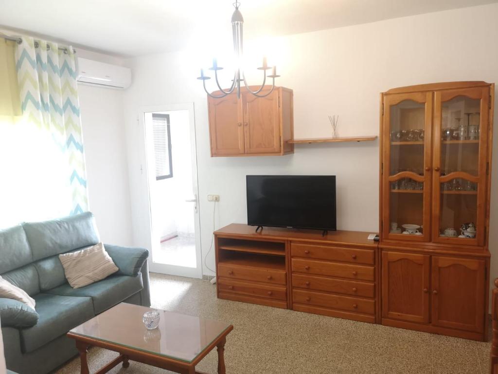 sala de estar con sofá y TV en un armario en Vivienda Turística en Jédula, en Jedula