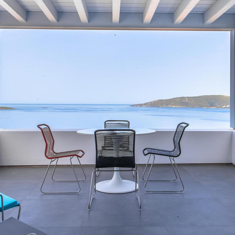 three chairs and a table with a view of the ocean at Blue Frames Summer House in Andros