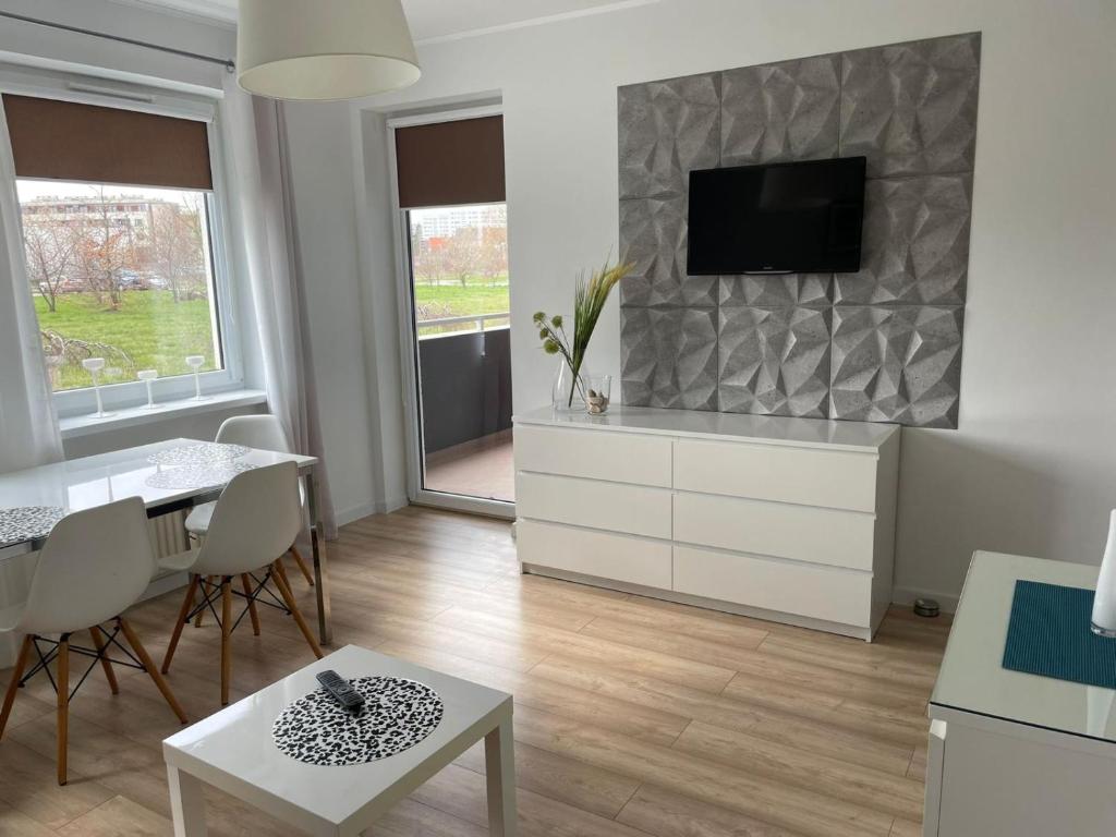 Televízia a/alebo spoločenská miestnosť v ubytovaní Apartament Ogrody