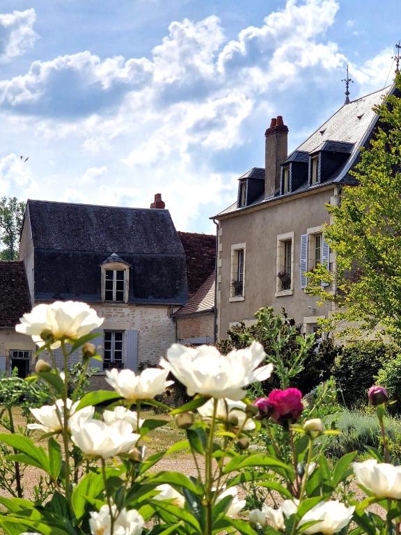une maison avec un jardin fleuri devant elle dans l'établissement Chambre d'hôtes 