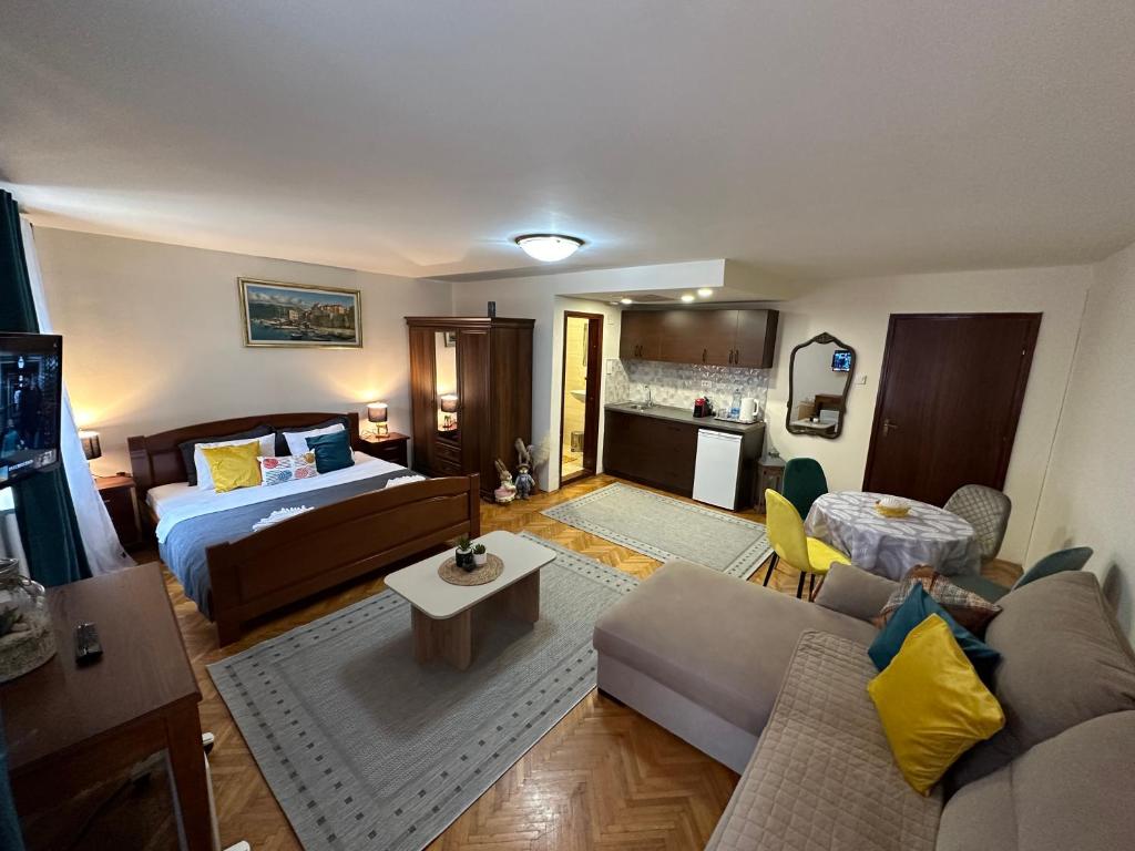 - un salon avec un canapé et un lit dans l'établissement Beatrix Suites, à Budva