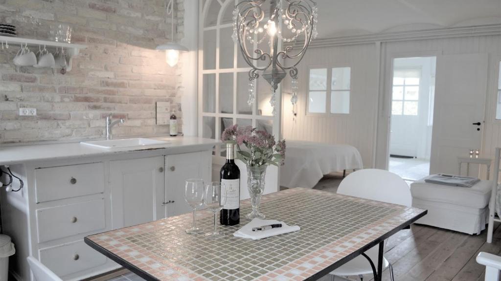 a kitchen with a table with a bottle of wine at Store Ejlstrup Bed & Breakfast in Odense