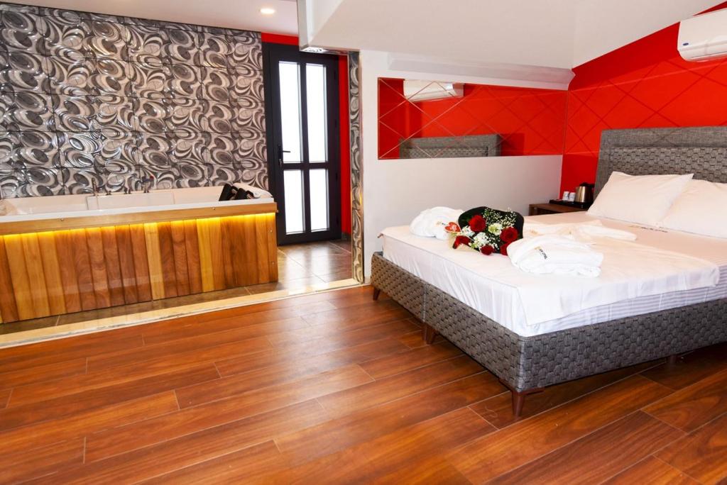 1 dormitorio con 2 camas y bañera en Renk Otel Karşıyaka, en Karşıyaka