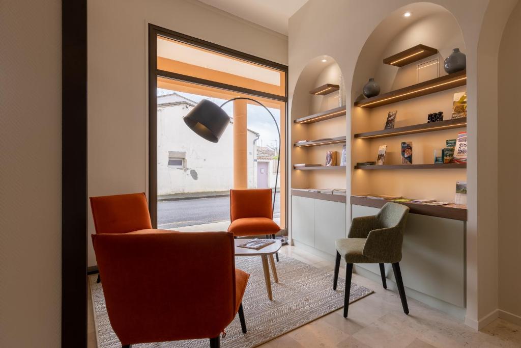 a dining room with orange chairs and a table at Brit Hotel Europ Bergerac in Bergerac