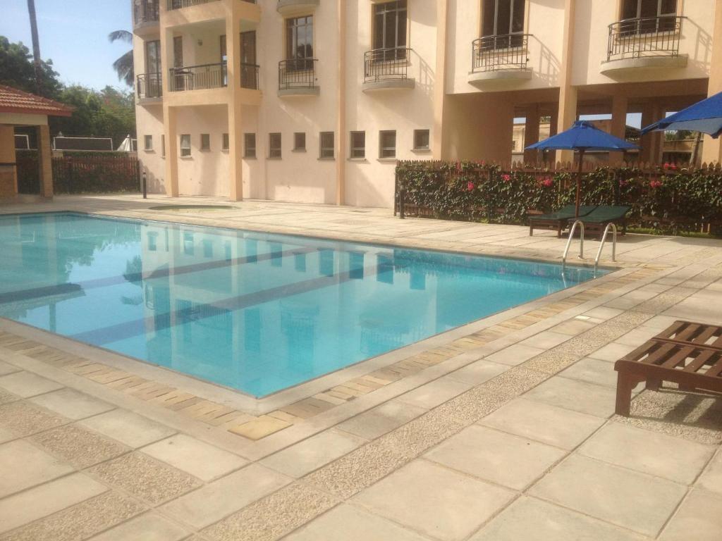 a swimming pool in front of a building at Bamburi Beach Homes in Bamburi