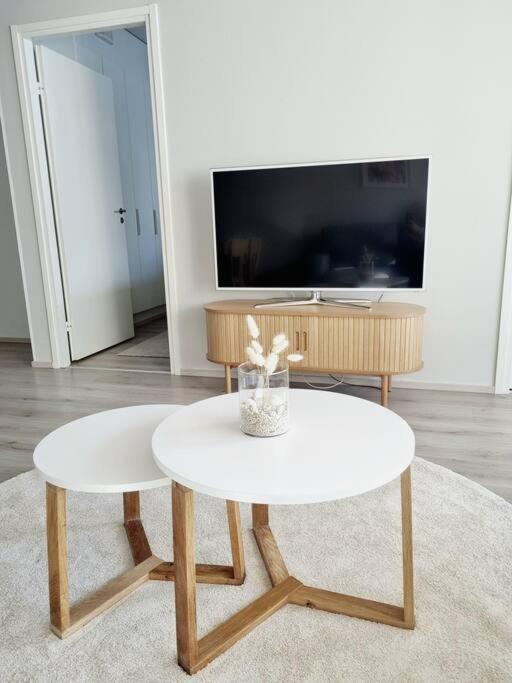 a living room with a white table and a tv at Villa Kaisla in Raahe