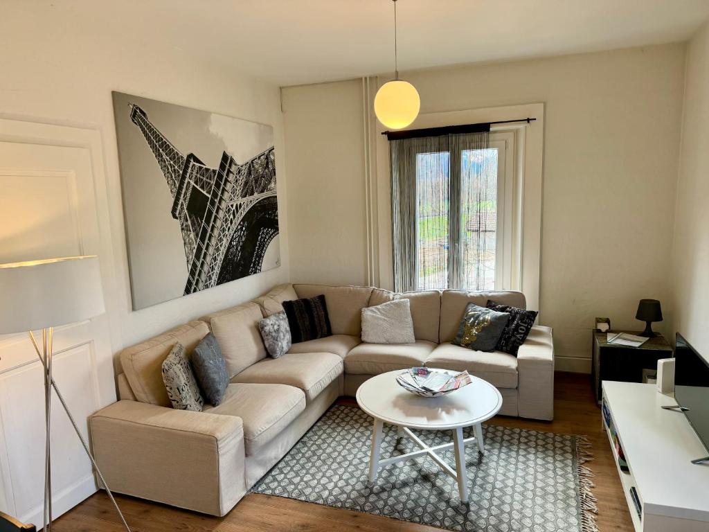 uma sala de estar com um sofá e uma mesa em Appartement em Couvet