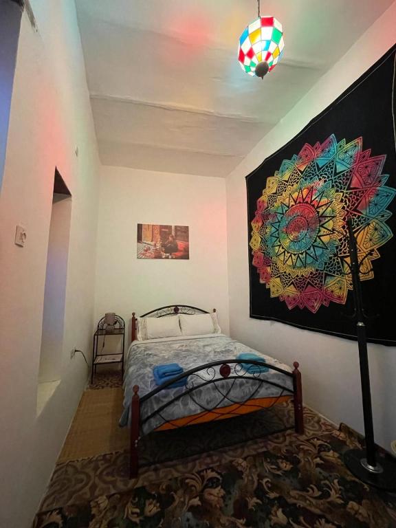 a bedroom with a bed and a painting on the wall at Dar Mora in Tangier