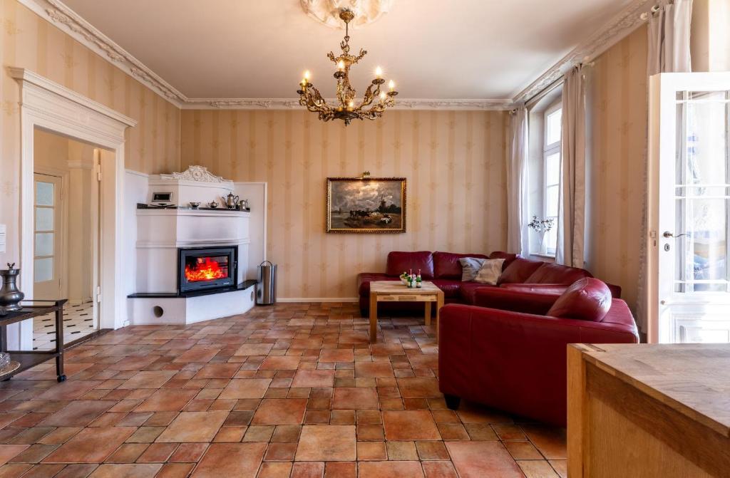 uma sala de estar com um sofá vermelho e uma lareira em Salon em Heringsdorf