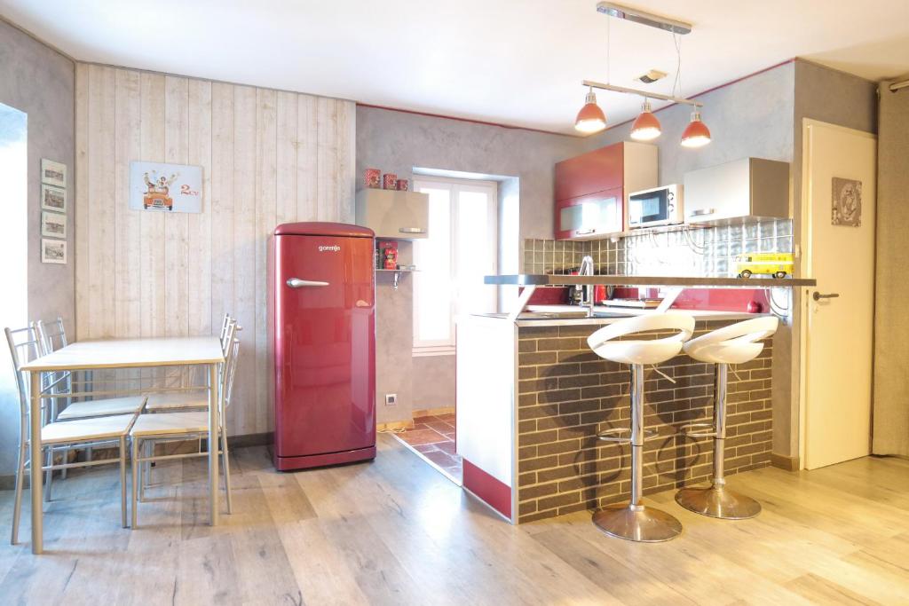 uma cozinha com um frigorífico vermelho e uma mesa em Studio à 100m de la grande plage des Sables d'Olonne - 2 pers em Les Sables-dʼOlonne
