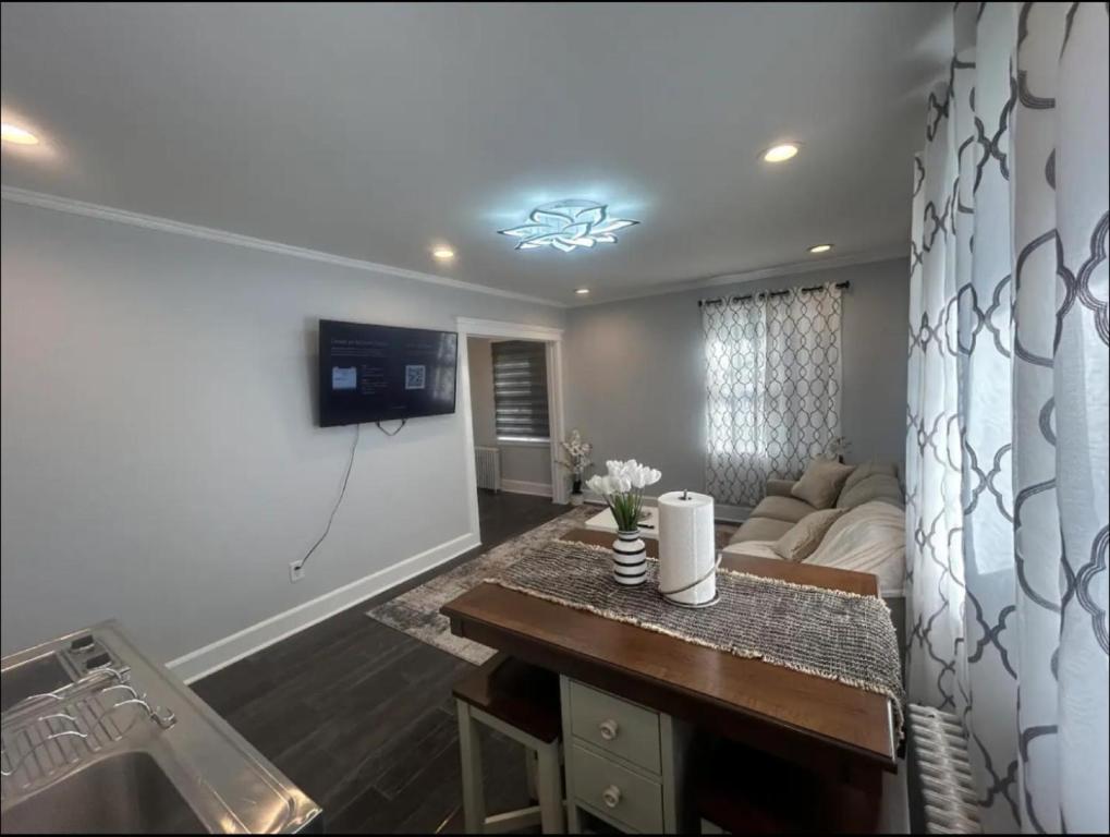 a living room with a couch and a tv on a wall at Private Suite In Huntington Station in Huntington Station