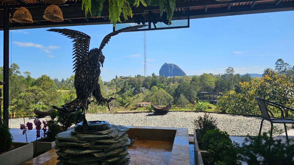 una estatua de un águila sentada en una roca en un jardín en Arvum Hotel Boutique en Guatapé