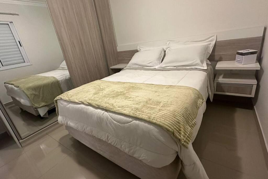 - une chambre avec un grand lit et un miroir dans l'établissement Próx Armando Panunzzio com piscina, à Sorocaba