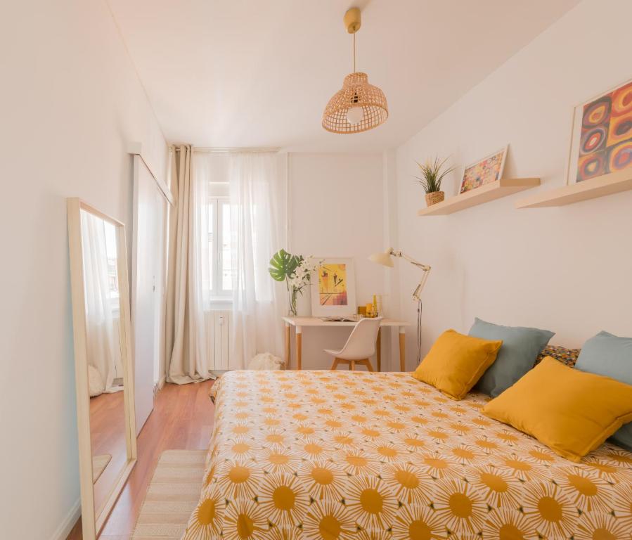 ein Schlafzimmer mit einem großen Bett mit gelben Kissen in der Unterkunft Brand new stylish ,spacious and cosy room with en suite bathroom in Madrid