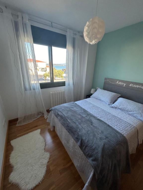 a bedroom with a bed and a large window at La Isla in Isla de Arosa