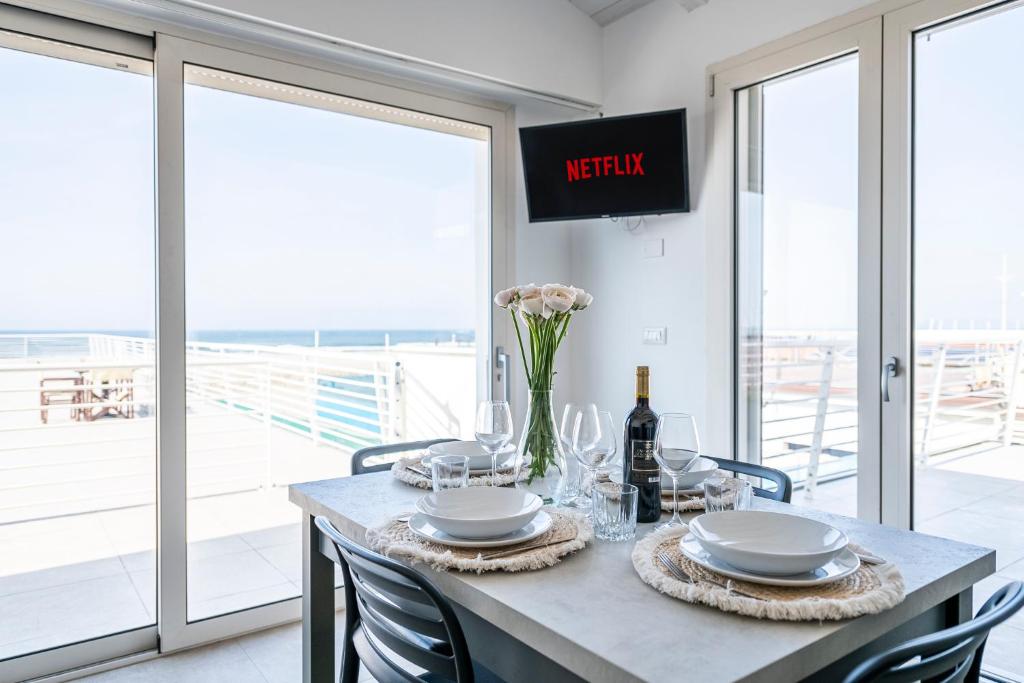 a dining room with a table and chairs with a view at Appartamento Luxury vista mare in Lido di Camaiore