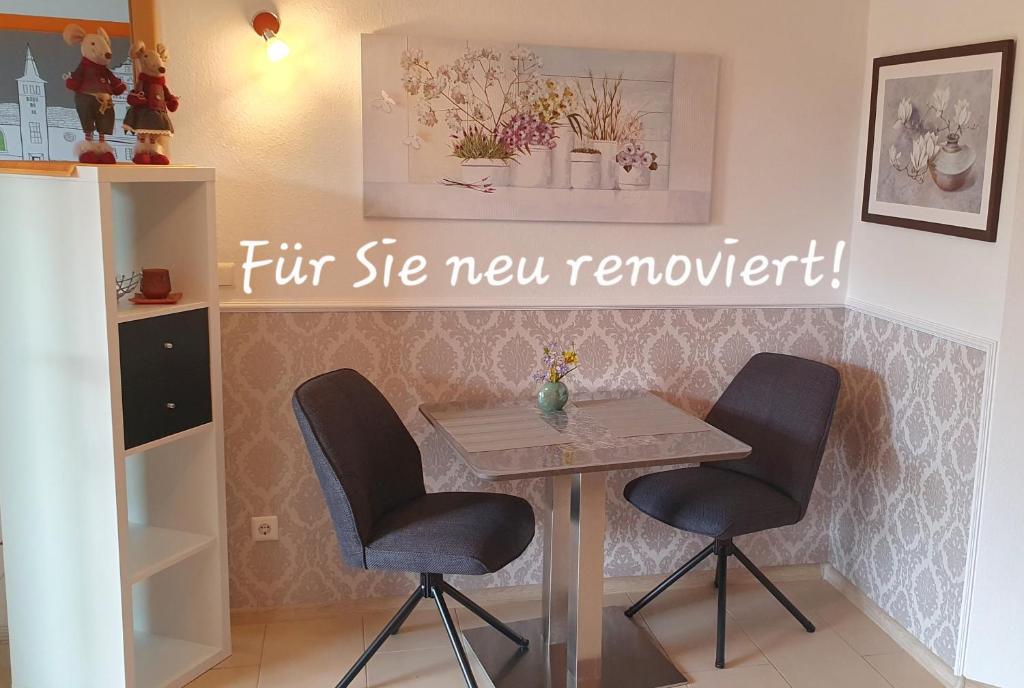 a table and two chairs in a room at Ferienwohnung Hameln Jasmin in Hameln