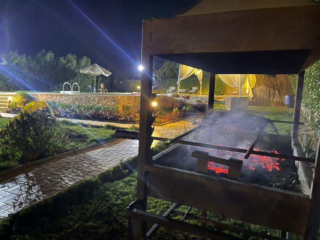 a grill in a garden at night at Dija's holiday rental in El-Qaṭṭa